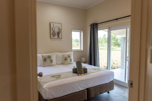 a bedroom with a bed and a sliding glass door at Aitutaki Holiday Villa in Arutanga