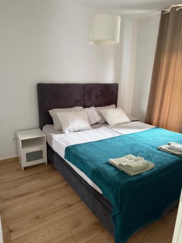 a bedroom with a large bed with a blue blanket at Apartman ‘Marko’ in Kutina