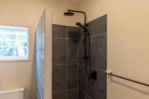 a bathroom with a shower with a shower head at Aitutaki Holiday Villa in Arutanga
