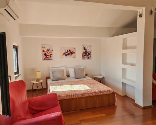 a bedroom with a bed and a red chair at Villa Finera in Premantura