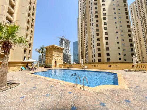 a swimming pool in a city with tall buildings at Spacious & classic Apartment in center of JBR in Dubai