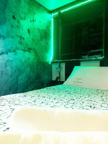 a bed in a room with a green light at Jim3 moterno studio fast wi-fi with a view in Andravída