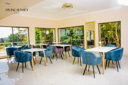 a dining room with tables and chairs and windows at Olifile Boutique Hotel & Restaurant in Midrand