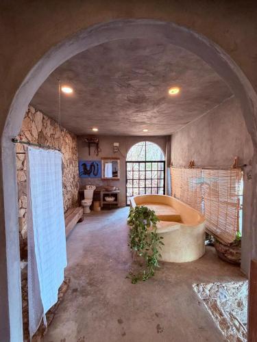 ein großes Badezimmer mit Badewanne und Steinwand in der Unterkunft Casa Guií in Arroyo Cruz