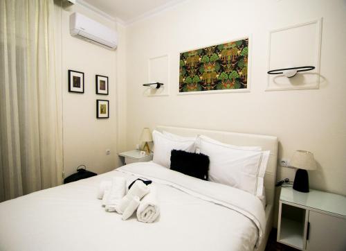 a bedroom with a white bed with towels on it at Twins in Serres