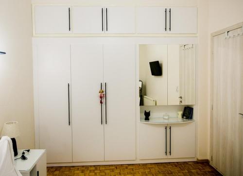 a white kitchen with white cabinets and a table at Twins in Serres
