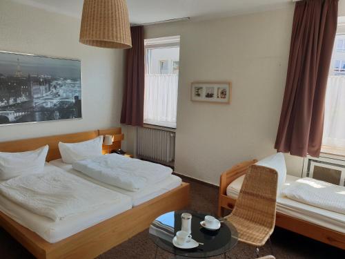 a hotel room with two beds and a table at Südhotel in Paderborn