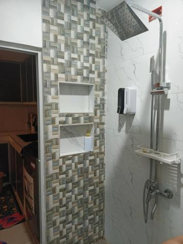 a bathroom with a tiled wall with a sink at Caperina del Casa-Rental in Naic