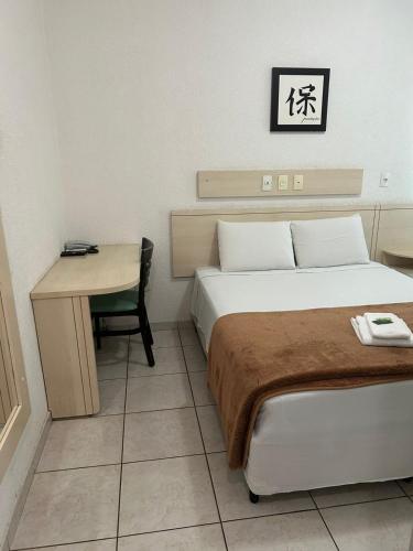 a bedroom with a bed and a desk and a table at Argentin Palace Hotel in Americana
