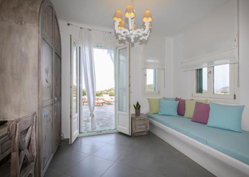 a living room with a blue couch in front of a window at Aegean Queen Villas - Onar Hotels Collection in Naousa