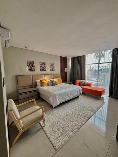 a large bedroom with a large bed and a chair at The Legacy Hotel and Spa in Tzaneen