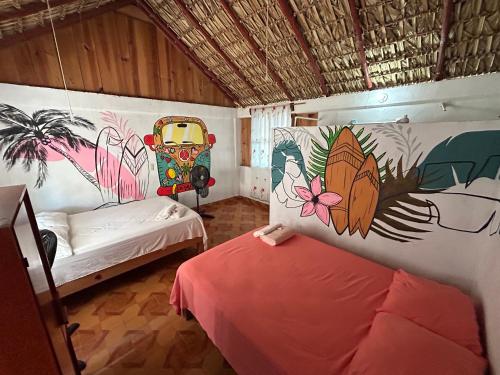 a room with two beds and a painting on the wall at Terra Tipi in Guayabas