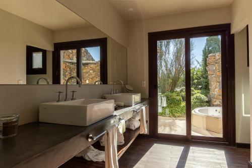 a bathroom with two sinks and a large mirror at Awasi Mendoza in Ciudad Lujan de Cuyo