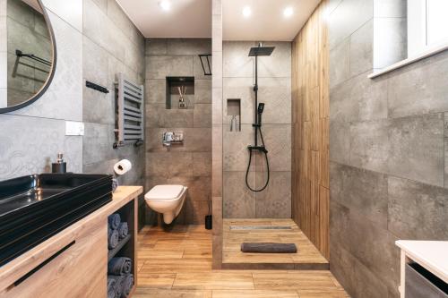 a bathroom with a shower and a toilet at Derylovka - domki, jacuzzi, sauna in Zamość