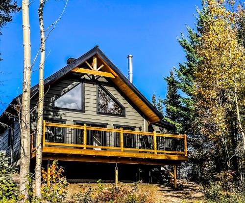 a house with a large deck on the side of it at Chalet cozy en bord de lac in Saguenay