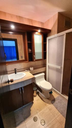 a bathroom with a white toilet and a sink at PREMIUM Puerto Varadero Apartamento con Vista al Mar y Planta Total in Tucacas