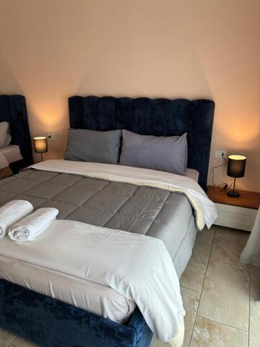 a bedroom with a large bed with a blue headboard at Bejart Apartment 8 in Tirana