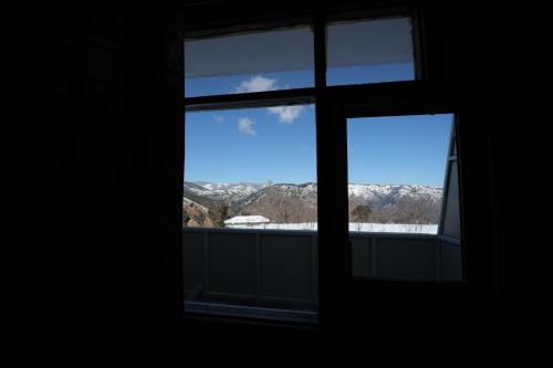 an open window with a view of the mountains at Village Crown in Mundaghat 