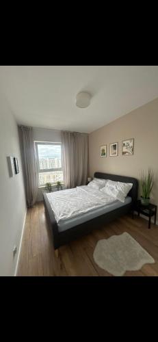 a bedroom with a large bed and a window at SeaView Apartament in Gdańsk Letnica