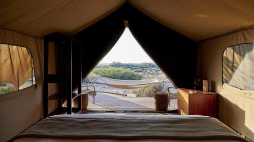 a room with a bed in a tent with a view at Sal Salis Ningaloo Reef in Exmouth