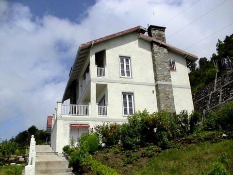 a white house on top of a hill at Cosmos HImalayan Villas in Rānīkhet