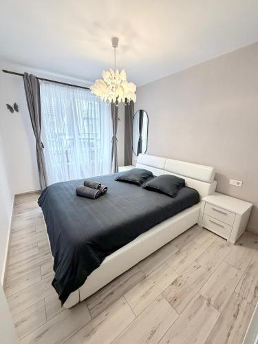 a bedroom with a large bed and a chandelier at FLH - Obralix Home in Sibiu