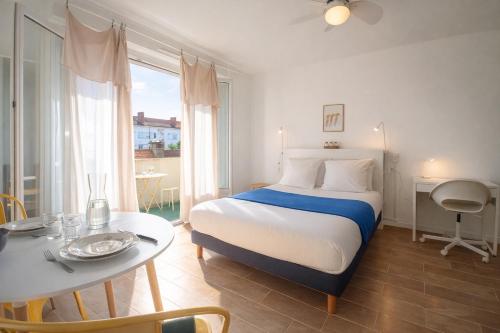 a bedroom with a bed and a table and a table and a bed at Le Kuku Beach - Appartement de charme à Digoin in Digoin