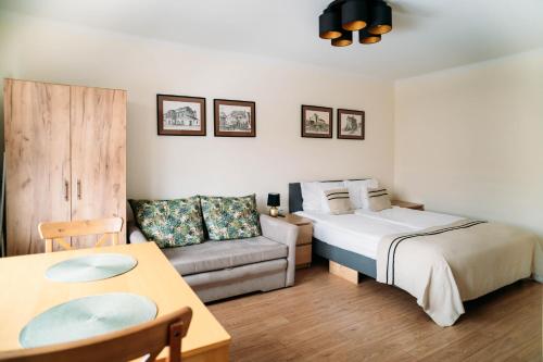 a bedroom with a bed and a couch and a table at Apartament Sandomierski in Sandomierz