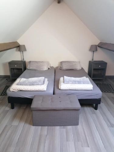two twin beds in a room with two night stands at Studio Paisible in Nouzilly