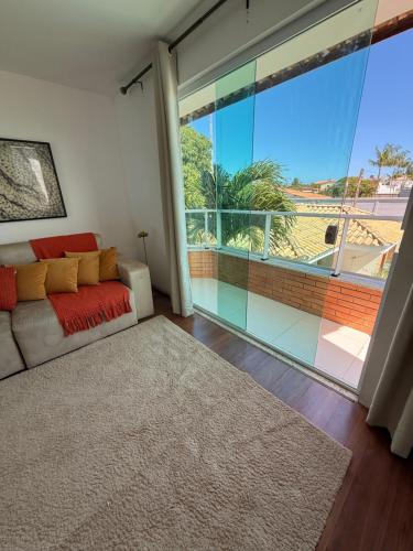 a living room with a couch and a large window at Pousada Casa de Praia in Marechal Deodoro