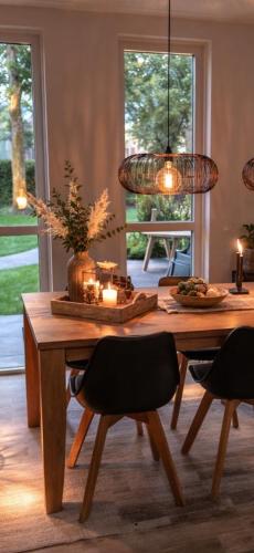 a dining room with a table with chairs and a light fixture at CasaJos Rust en Comfort vlakbij Nijmegen in Ewijk