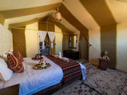 a bedroom with a bed with two stuffed animals on it at Dream Land Camp in Merzouga