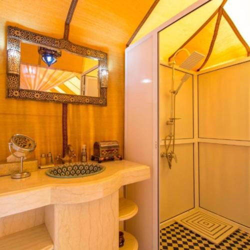 a bathroom with a sink and a shower at Dream Land Camp in Merzouga