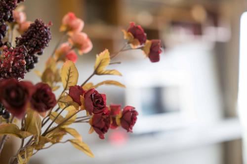 a bouquet of red flowers in a vase at The Residence Thepkanjana in Ban Khlong Krathum Baen
