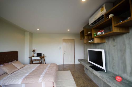 a bedroom with a bed and a flat screen tv at The Residence Thepkanjana in Ban Khlong Krathum Baen