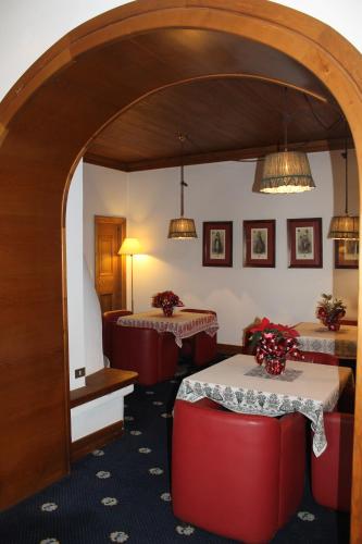 a room with two tables and red chairs at Hotel Majoni in Cortina dʼAmpezzo