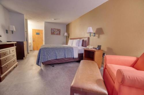 a hotel room with a bed and a couch at Zanesville Inn in Zanesville