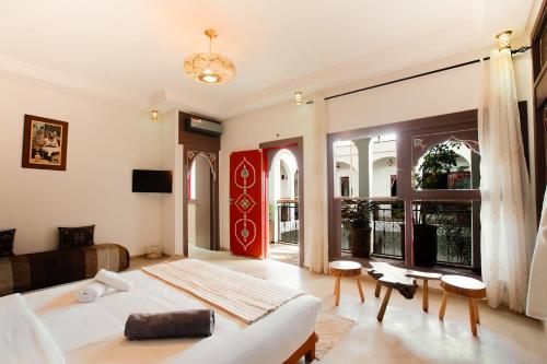 a bedroom with a bed and a living room with a couch at Riad Dar Mima Hnina - 2 Pools, Breakfast, 10' From Jamaa el-Fna, 10' From Airport in Marrakesh