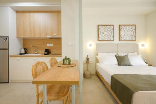 a bedroom with a bed and a table and a kitchen at Leon Apartments in Ierissos