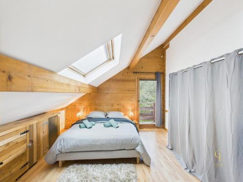 a bedroom with a bed and a skylight at Cozy chalet with Nordic bath in Plancher-Bas