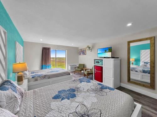 a bedroom with two beds and a television in it at CRYSTAL PALACE RESORT in Bolivar Peninsula