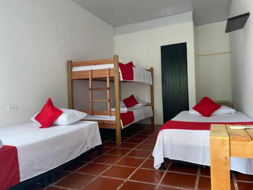 two beds in a room with red and white at Cabañas Spacetatacoa in Villavieja
