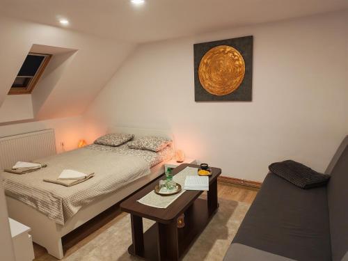 a small bedroom with a bed and a table at Csergeteg Családi szállás in Ciceu