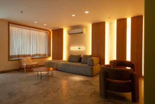 a living room with a couch and a table and chairs at Regency Copacabana Hotel in Rio de Janeiro