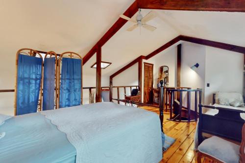 a bedroom with a large bed with blue curtains at Adirondacks in Style! Lake House w/ Deck, Fire Pit in Hadley