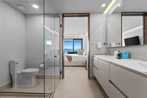 a bathroom with a toilet and a sink and a bedroom at Panarea Beachfront Living - Pools Spa Gym & Luxury Amenities in Bucerías