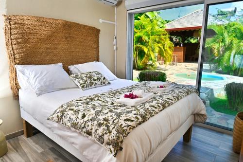 a bedroom with a bed with a view of a pool at Cottage Vanda in Le Moule