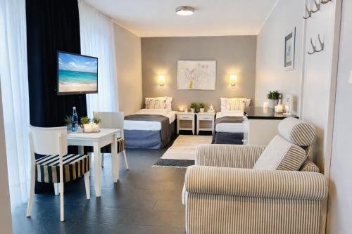 a room with two beds and a living room at HOTEL Amber Suite & SPA - Enklawa dla Dorosłych in Międzywodzie