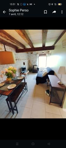 a living room with a table and a couch at L'écurie du Mas in Lamothe-Cassel