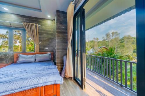 a bedroom with a bed and a balcony at Thiên Vy Homestay in Phú Quốc
